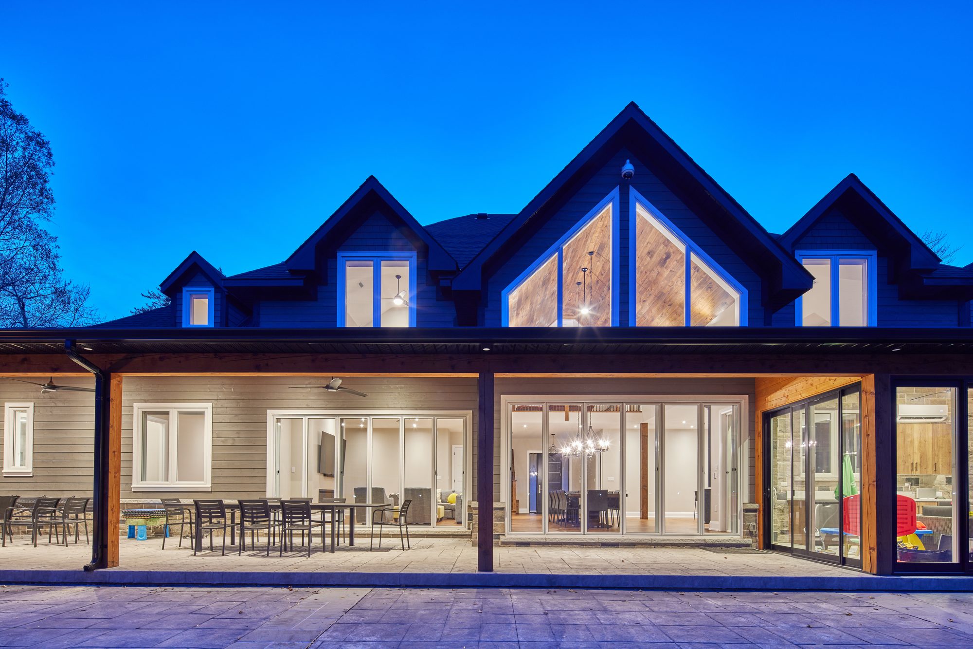 Completed GCD home at twilight, timber-lined alfresco and full-height glazing lit from within